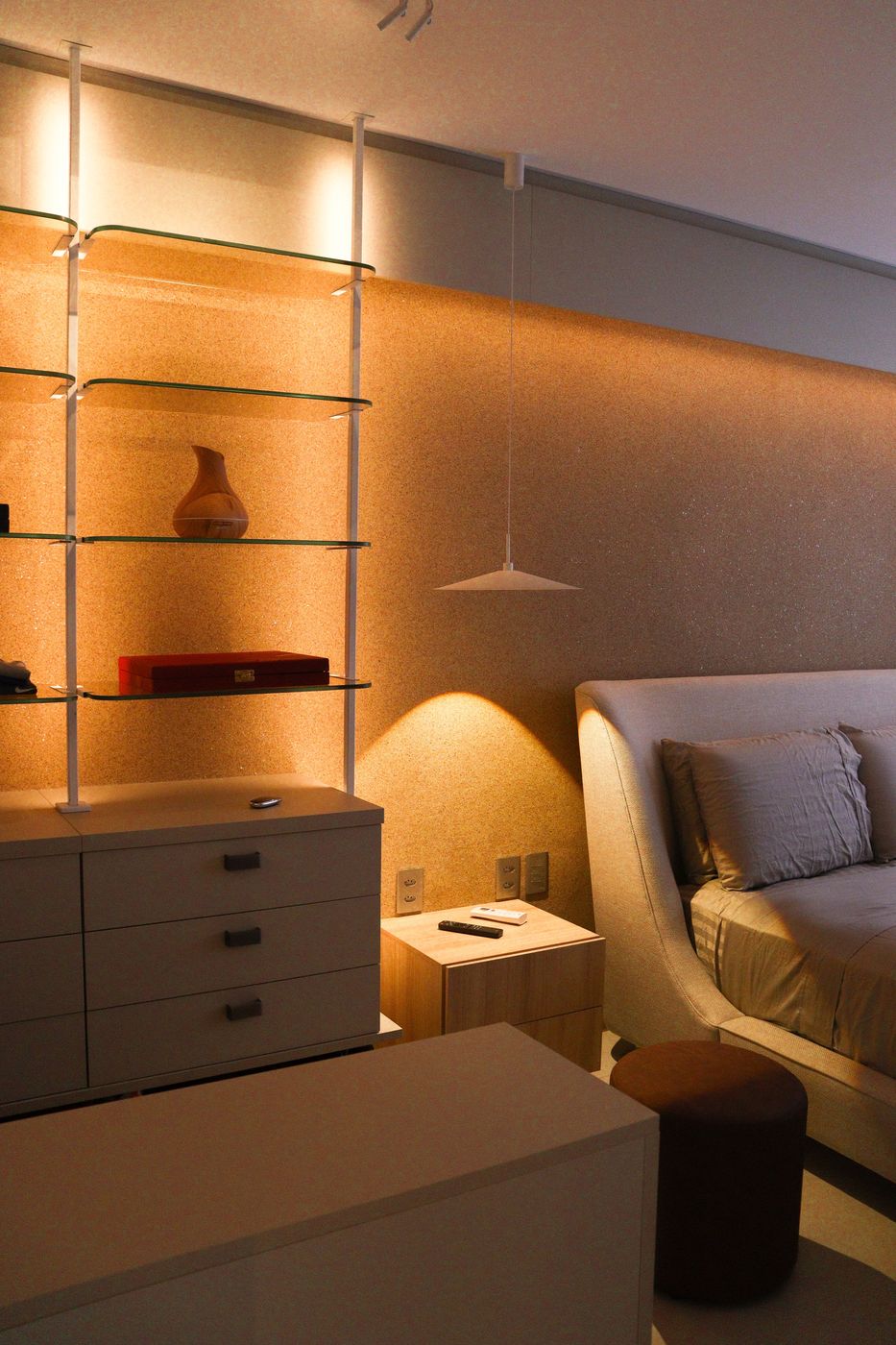 Suíte com cômoda, prateleiras e iluminação quente